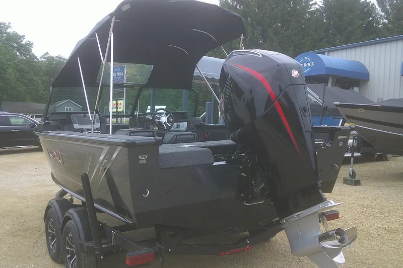 Slide: The Image of 2025 Lund 1875 Pro-V boat with outboard motor, parked on a trailer. - 3