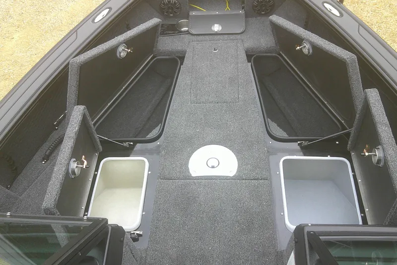 Slide: The Image of 2025 Lund 1875 Pro-V boat interior with open storage compartments and carpeted flooring. - 7