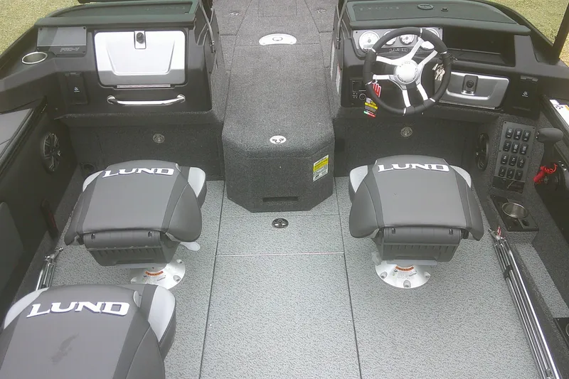 Slide: The Image of 2025 Lund 1875 Pro-V boat interior with steering wheel and branded seats. - 9