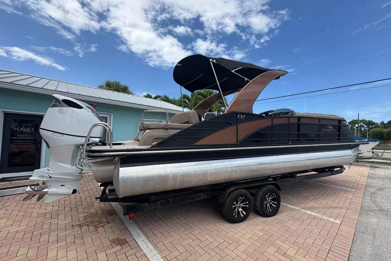 Slide: The Image of 2019 Bennington 25 QSBA pontoon boat with Suzuki outboard motor on trailer. - 19