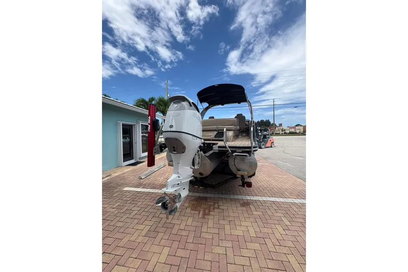 Slide: The Image of 2019 Bennington 25 QSBA pontoon boat with outboard motor, parked on brick pavement. - 21