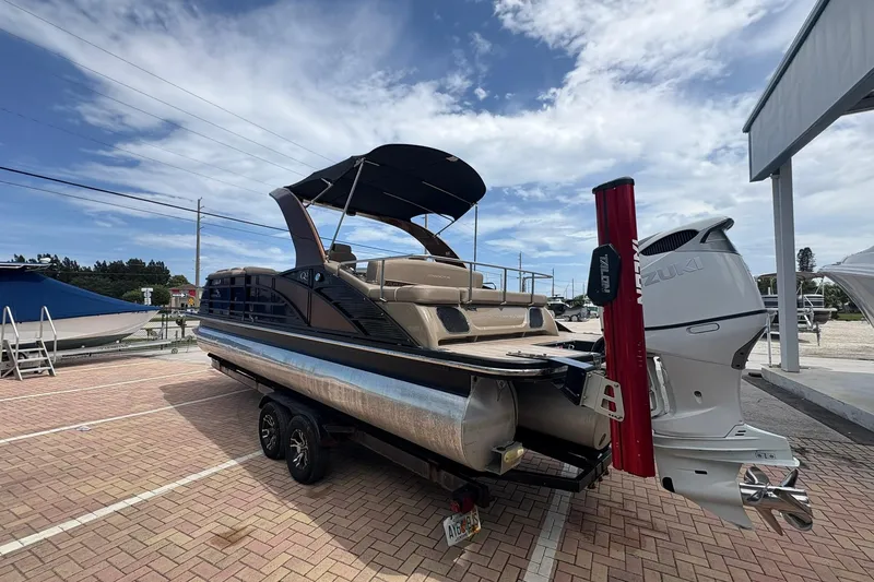 Slide: The Image of 2019 Bennington 25 QSBA pontoon boat on trailer, featuring Suzuki outboard motor. - 23