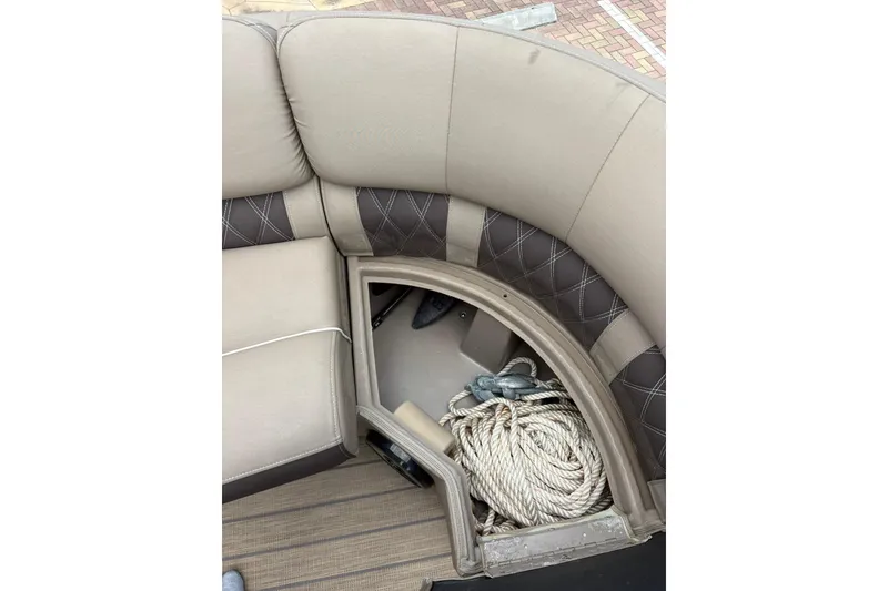 Slide: The Image of 2019 Bennington 25 QSBA boat interior with storage compartment and coiled rope. - 5