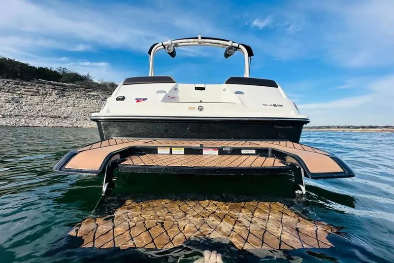 Slide: The Image of 2017 Sea Ray SLX-W 230 boat on water, rear view with swim platform. - 4