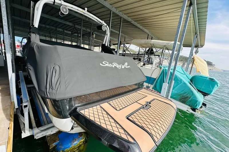 Slide: The Image of 2017 Sea Ray SLX-W 230 boat docked under a covered marina. - 5