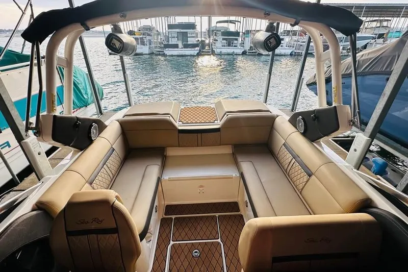 Slide: The Image of 2017 Sea Ray SLX-W 230 boat interior with tan seating, docked by the water. - 7