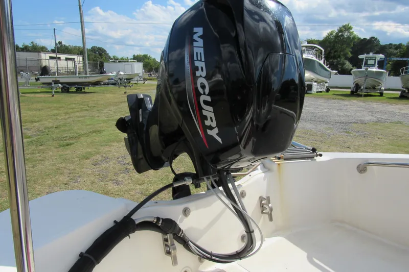 Slide: The Image of 2021 Boston Whaler 130 Super Sport boat interior with white seating and Mercury engine. - 10