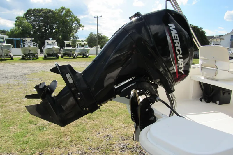 Slide: The Image of 2021 Boston Whaler 130 Super Sport with Mercury outboard motor, docked on grass. - 4