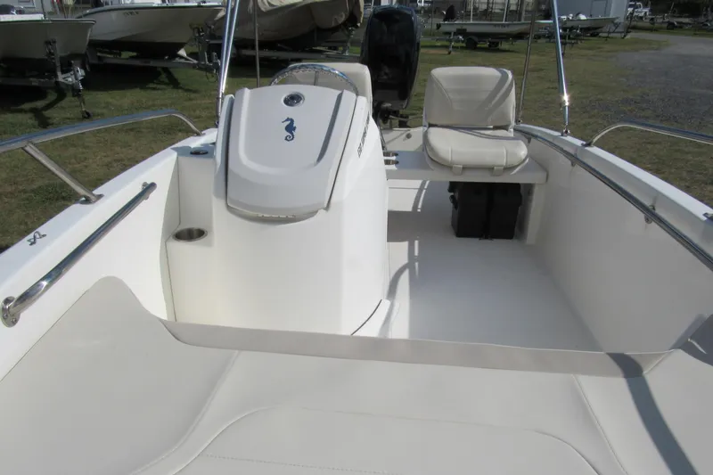 Slide: The Image of 2021 Boston Whaler 130 Super Sport with Mercury outboard engine, parked on grass. - 6