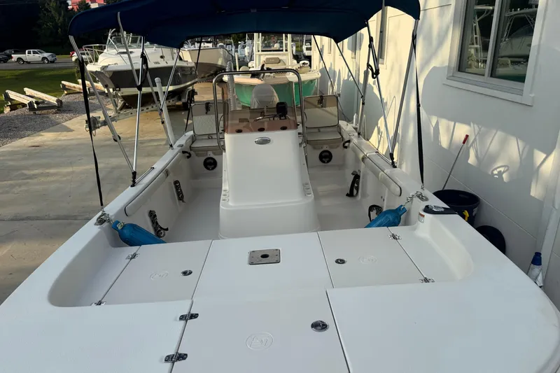 Slide: The Image of 2022 Carolina Skiff 17 LS boat interior with seating and canopy in a marina setting. - 5