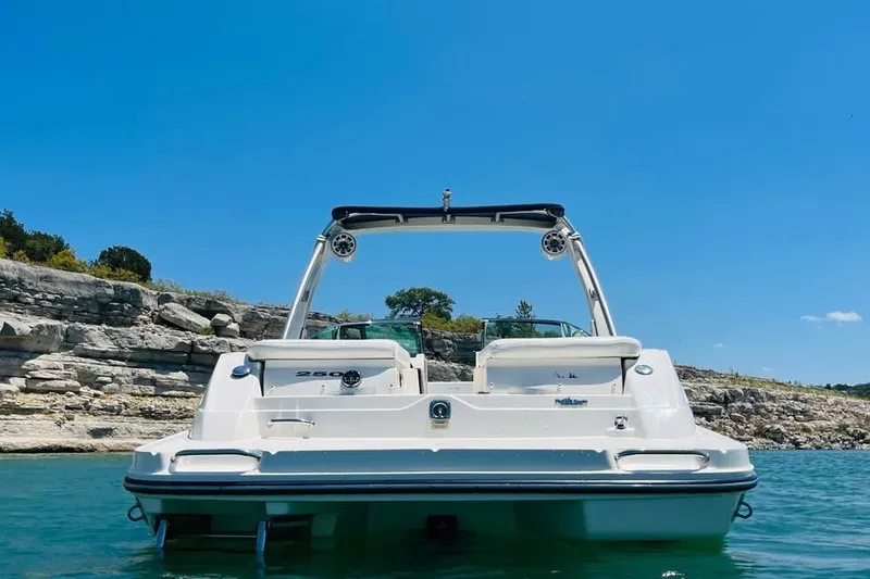 Slide: The Image of 2008 Sea Ray 250 SLX boat on clear blue water with rocky shoreline backdrop. - 3