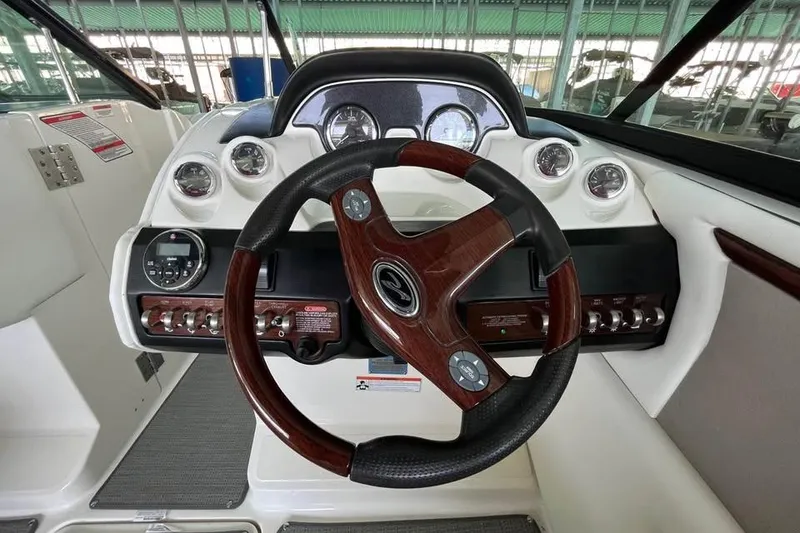 Slide: The Image of Steering wheel and dashboard of 2008 Sea Ray 250 SLX boat, featuring gauges and controls. - 8