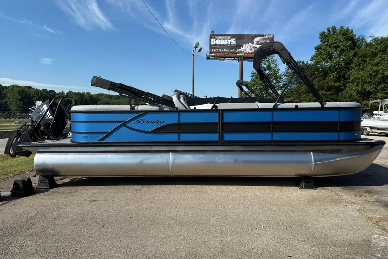 Slide: The Image of 2025 Bentley Pontoons Legacy 243 Navigator, blue pontoon boat on display outdoors. - 3