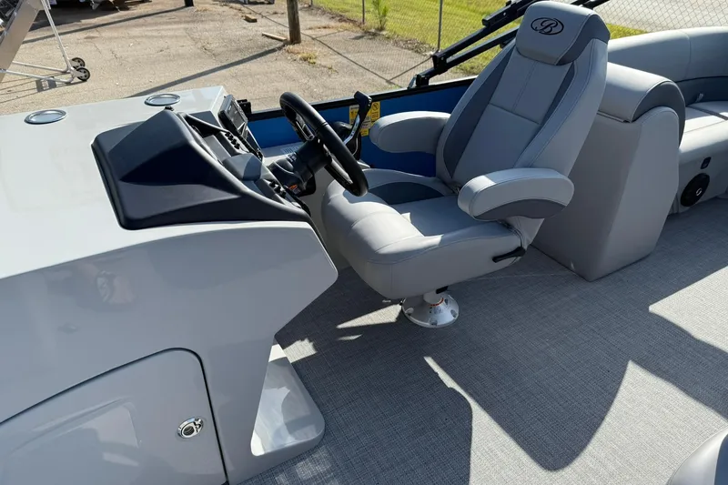 Slide: The Image of 2025 Bentley Pontoons Legacy 243 Navigator helm with luxurious captain's chair and sleek dashboard. - 7