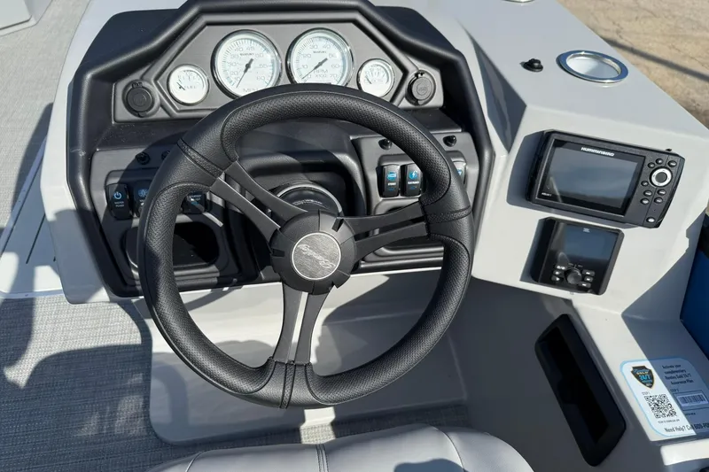 Slide: The Image of 2025 Bentley Pontoons Legacy 243 Navigator dashboard with steering wheel and navigation controls. - 8