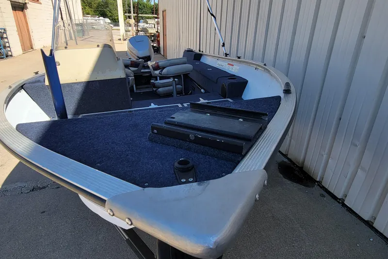 Slide: The Image of 1997 Sea Nymph 168 DLX boat on trailer beside a metal building. - 2