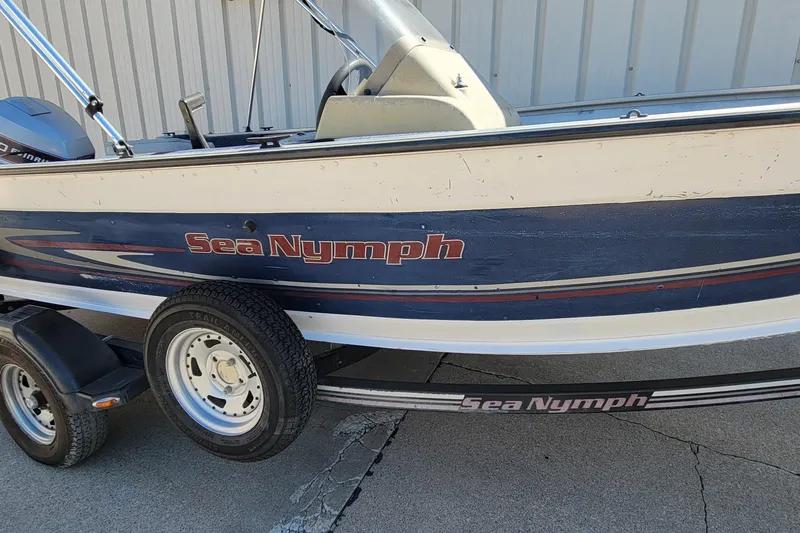 Slide: The Image of 1997 Sea Nymph 168 DLX boat on trailer, side view, parked on concrete. - 3