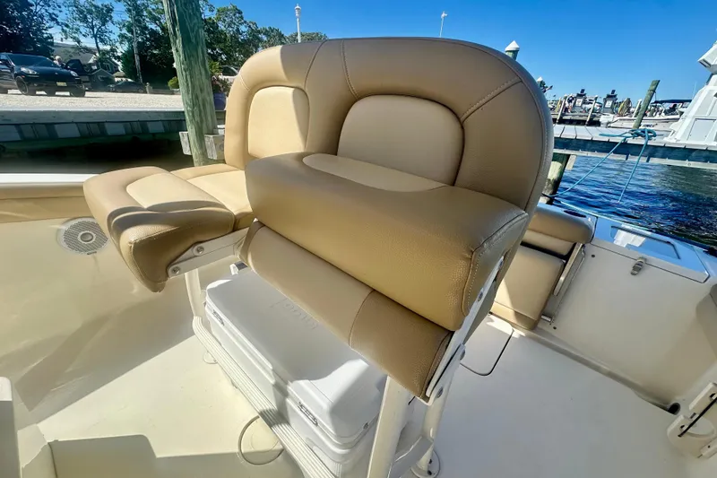 Slide: The Image of 2020 Scout 215 XSF boat with tan seating and cooler on deck. - 4