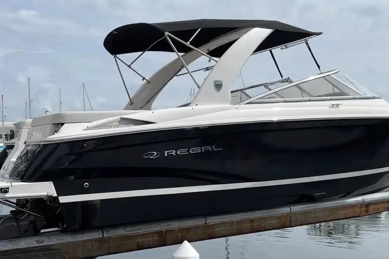 Slide: The Image of 2016 Regal 2700 ES Bowrider boat docked, featuring sleek design and black hull. - 2