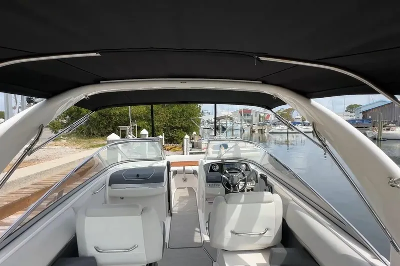 Slide: The Image of 2016 Regal 2700 ES Bowrider interior view at marina, featuring sleek seating and dashboard. - 6