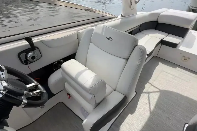 Slide: The Image of 2016 Regal 2700 ES Bowrider interior with steering wheel and seating, docked by water. - 7