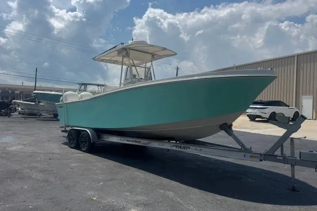 The Image of 1992 Mako 261B boat on trailer, parked outdoors under a cloudy sky. - 0