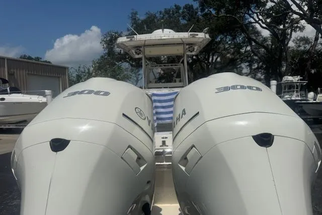 Slide: The Image of 1992 Mako 261B boat with twin Yamaha 300 engines, docked outdoors. - 11