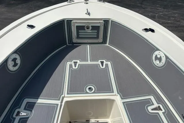 Slide: The Image of 1992 Mako 261B boat interior with gray deck and storage compartments. - 19