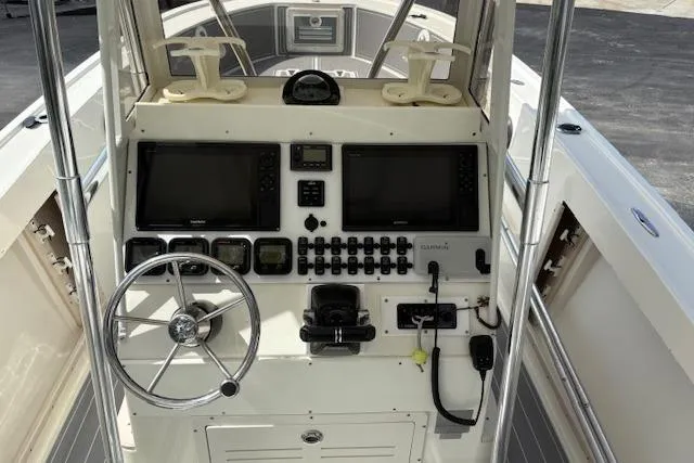 Slide: The Image of 1992 Mako 261B boat console with steering wheel, dual screens, and control panel. - 22