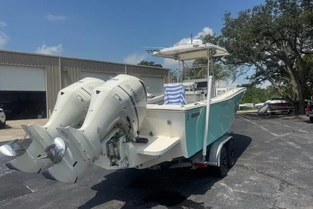 Slide: The Image of 1992 Mako 261B boat with dual outboard motors on a trailer, parked outdoors. - 4