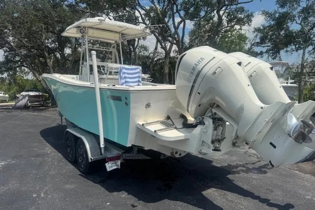 Slide: The Image of 1992 Mako 261B boat with Yamaha outboard engines on a trailer, parked outdoors. - 7