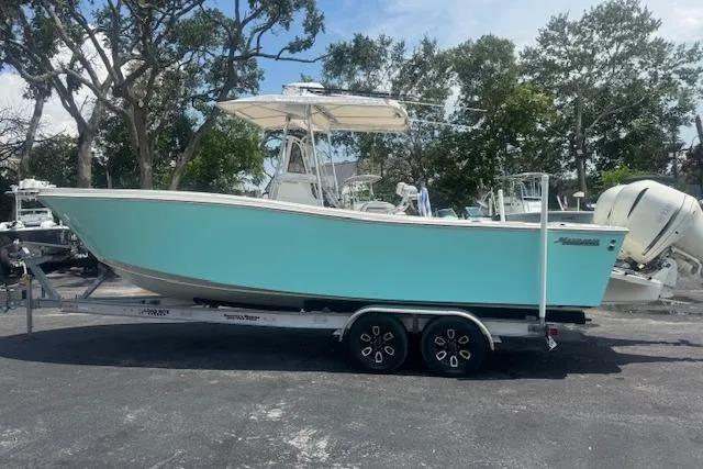 Slide: The Image of 1992 Mako 261B boat on trailer, light blue hull, parked outdoors. - 8