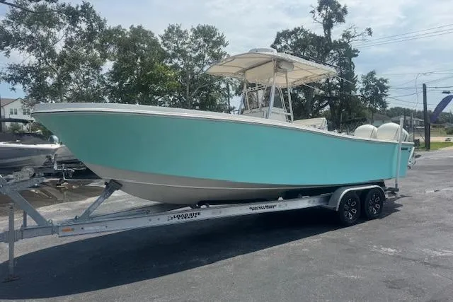 Slide: The Image of 1992 Mako 261B boat on trailer, light blue hull, parked outdoors. - 9