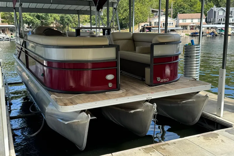 Slide: The Image of 2017 Crest II 250 SLE pontoon boat docked on a serene lake. - 3