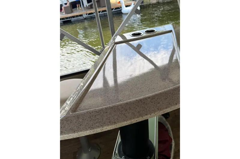 Slide: The Image of 2017 Crest II 250 SLE boat table with cup holders, reflecting sky and water. - 5