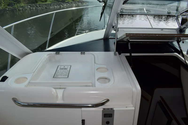 Slide: The Image of 2002 Tiara 2900 Coronet boat interior with sink and cup holders, docked on a calm river. - 13
