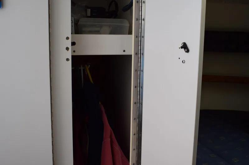 Slide: The Image of Open closet on a 2002 Tiara 2900 Coronet boat, showing hanging clothes and storage. - 19