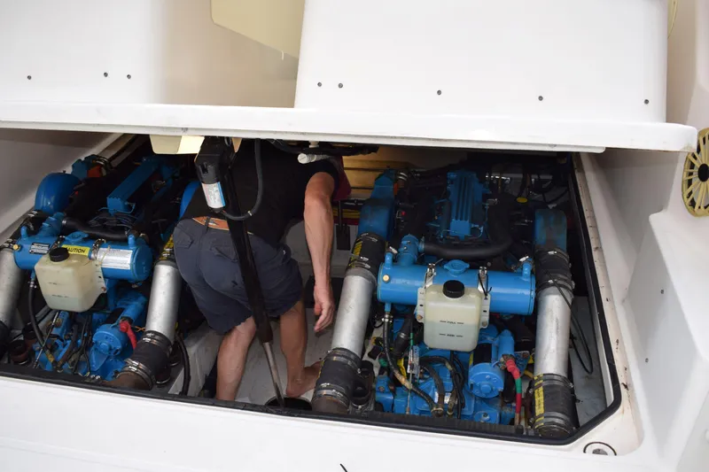 Slide: The Image of Man inspecting engine compartment of 2002 Tiara 2900 Coronet boat. - 21