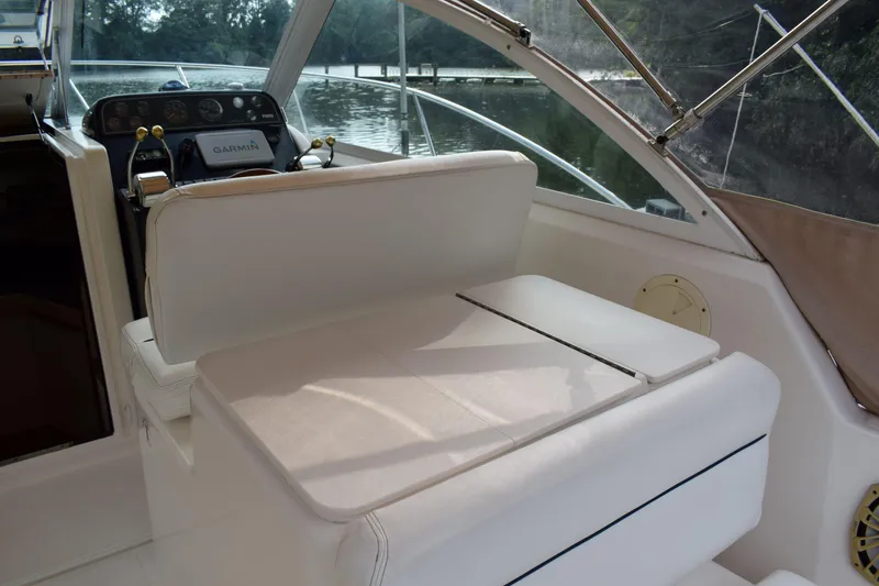 Slide: The Image of 2002 Tiara 2900 Coronet boat interior with white seating and Garmin navigation system. - 8