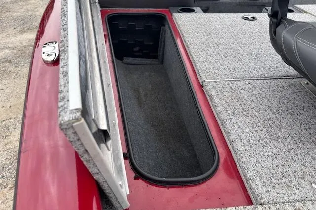 Slide: The Image of 2023 Tracker Pro Team 175 TXW boat storage compartment, open lid, red and gray interior. - 23