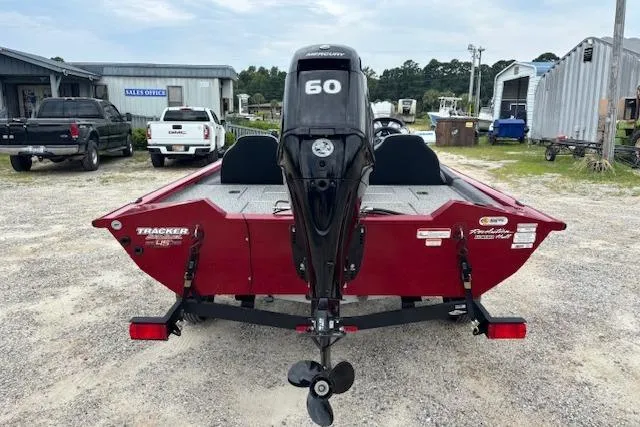 Slide: The Image of 2023 Tracker Pro Team 175 TXW boat, red, rear view with 60 HP motor, parked outdoors. - 3