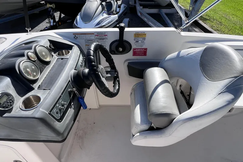 Slide: The Image of 2018 Bayliner 210 Deck Boat cockpit with steering wheel and gauges. - 11