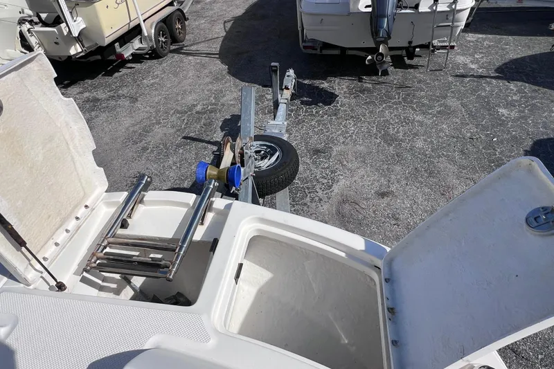 Slide: The Image of 2018 Bayliner 210 Deck Boat with open storage compartments and trailer hitch. - 18