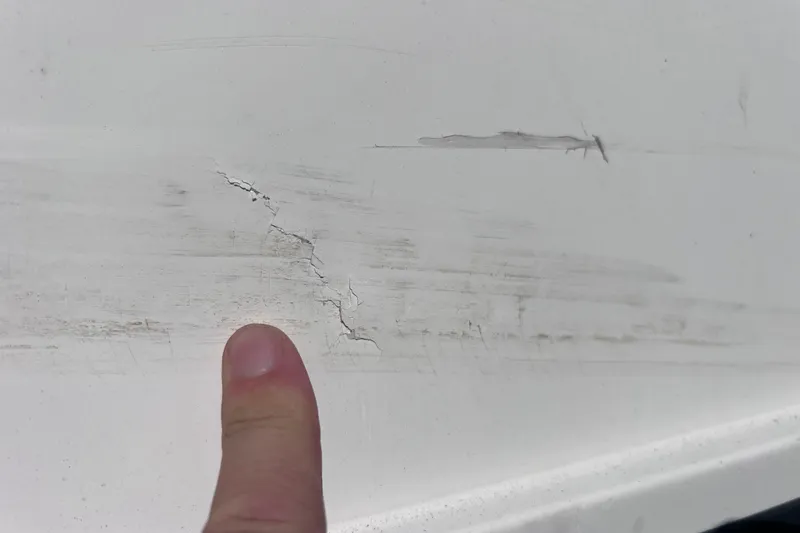 Slide: The Image of Crack on 2018 Bayliner 210 Deck Boat hull with finger pointing. - 25
