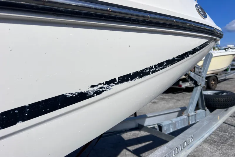 Slide: The Image of 2018 Bayliner 210 Deck Boat with visible hull damage on trailer. - 26