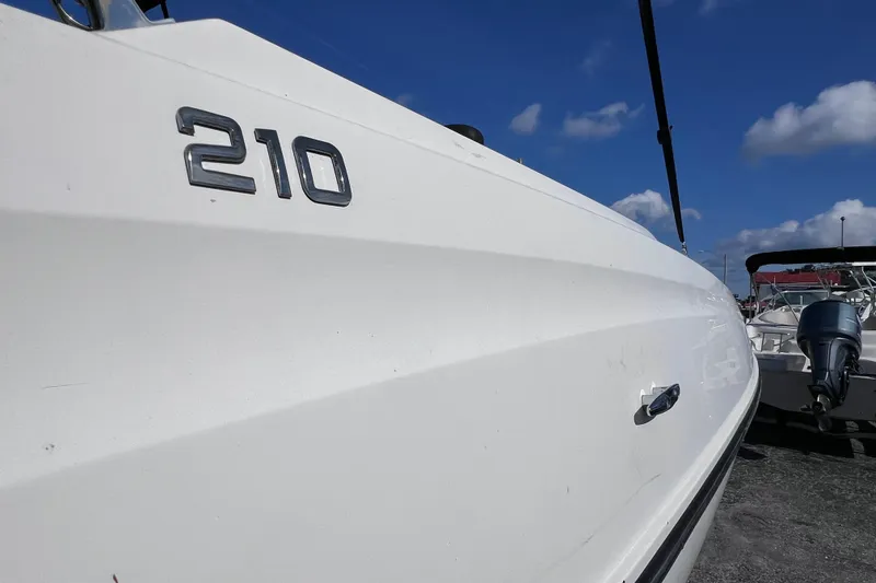Slide: The Image of Bayliner 210 Deck Boat 2018, side view with clear sky background. - 7