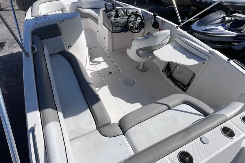 Slide: The Image of 2018 Bayliner 210 Deck Boat interior with seating, steering console, and storage compartments. - 9