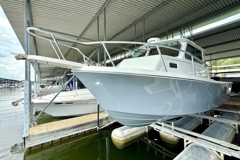 Slide: The Image of 2023 Parker 2820 XLD Sport Cabin boat docked under a covered marina. - 15