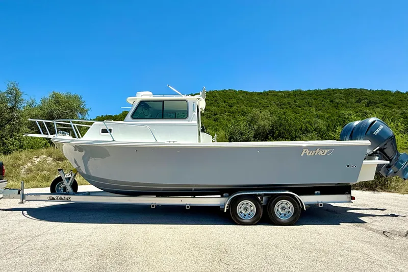 Slide: The Image of 2023 Parker 2820 XLD Sport Cabin boat on trailer, parked outdoors. - 17