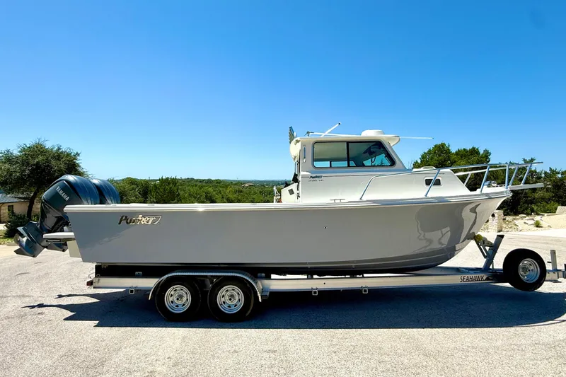 Slide: The Image of 2023 Parker 2820 XLD Sport Cabin boat on trailer, clear sky background. - 21